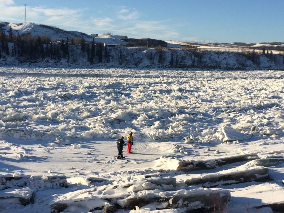 Workers by an ice jam on the Peace River measure the high water mark